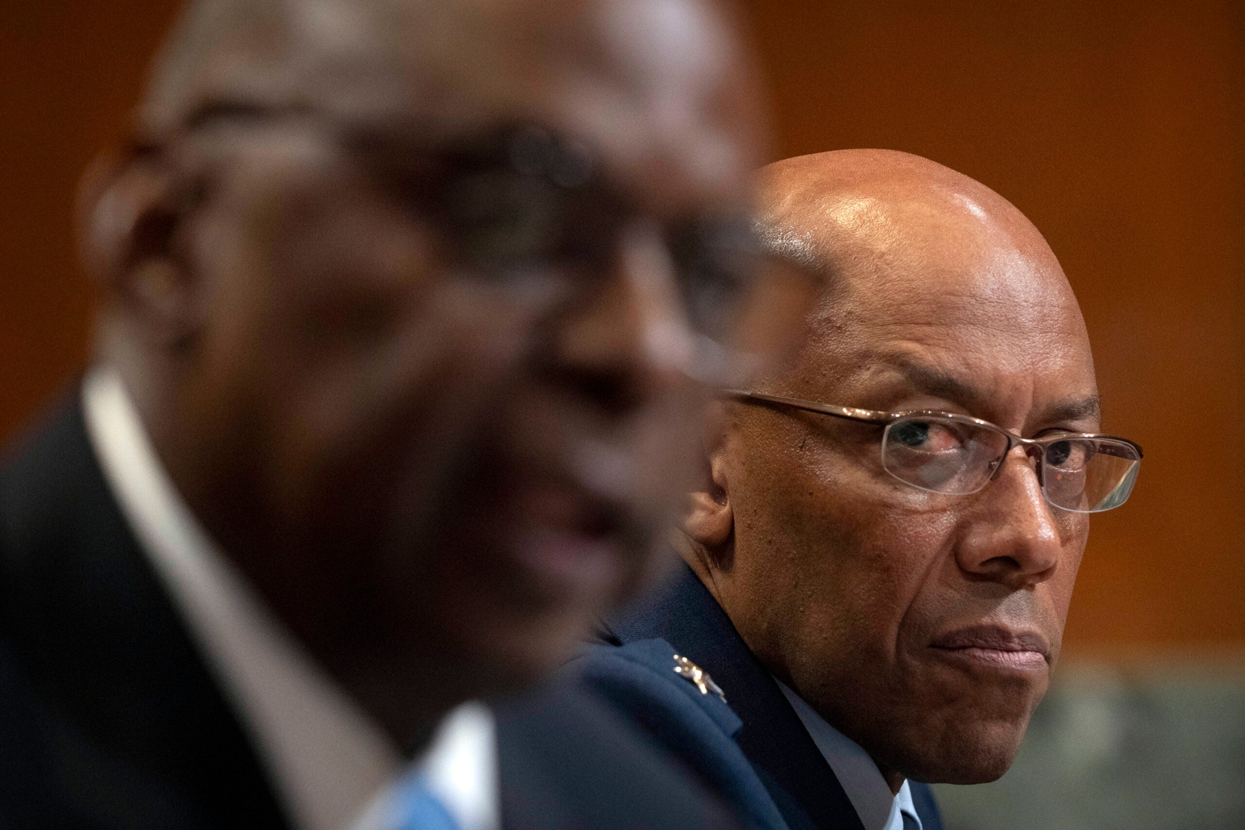 Chairman of the Joint Chiefs of Staff Air Force Gen. CQ Brown listens as Secretary of Defense Lloyd Austin speaks during a hearing.