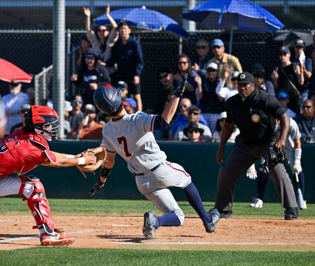 Beckman’s Zach Ireland (7) avoids being tagged by Los Alamitos’...