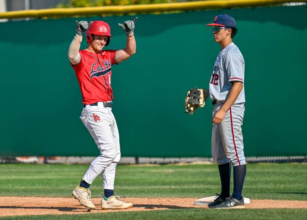 Los Alamitos’ AJ Cappell (14) celebrates reaching first with Beckman’s...