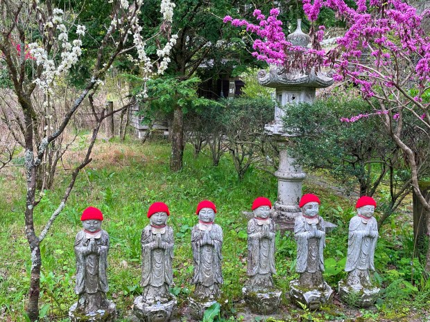 Watchful Buddhist-like Jizo statues appear on the Nakasendo trail wearing knit red beanies. Kind locals put hats on the Jizo to keep them warm. (Photo by Norma Meyer)