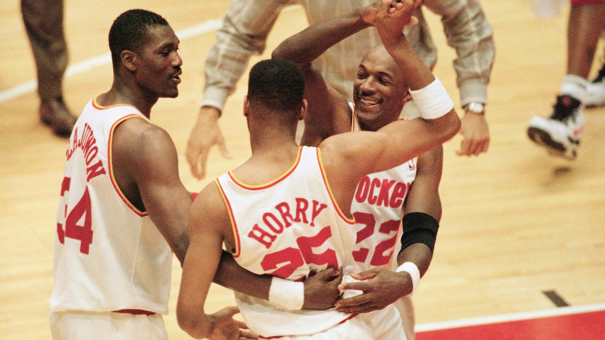 Houston Rockets' players Hakeem Olajuwon, left, Robert Horry (25), and Clyde Drexler (22) celebrate their victory over the Magic after Game 3 of the NBA Finals on June 11, 1995.