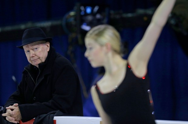 Frank Carroll, coach of figure skater Gracie Gold, keeps an eye on the skater as she practices at the Skate America figure skating competition Oct. 23, 2015, in Milwaukee. (AP Photo/Jeffrey Phelps, File)