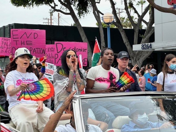 Lesbian singer Kehlani cheers in Code Pink Southeast LA’s procession...